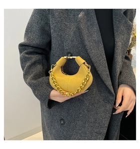 Primer plano de bolso media luna en ante amarillo jengibre con cadena dorada gruesa