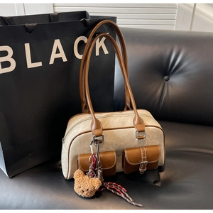 Close-up of contrast retro Boston bag with canvas texture, pockets and teddy pendant