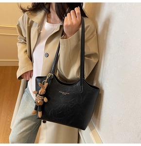 Détail du sac cabas noir en similicuir avec lettrage doré et pendentif lapin