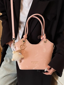 Sac seau rose à motif marbré avec poignée nouée et charm en peluche porté en bandoulière