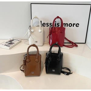 Collection of minimalist glossy leather handbags in white, burgundy, brown, and black