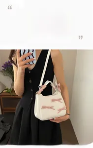 Detail showing three 3D pink bows on a cream small square crossbody bag for women