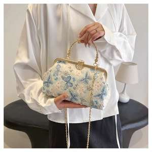 Detail der blauen Schmetterlingsstickerei auf einer Vintage-Handtasche mit Goldkette