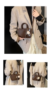 Détail d'un sac à main carré marron brillant avec un porte-clés en peluche doux