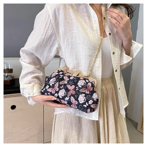 Detail einer eleganten chinesischen Sticktasche mit Schmetterlingsmuster und Goldkette