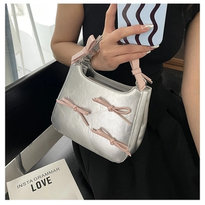 Detail view of silver metallic bag with cute pink bows and stylish hand strap