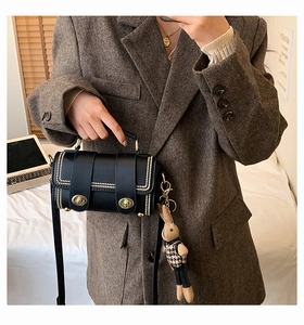 Detail of crossbody bag with gold stud trim and a stylish houndstooth bunny charm