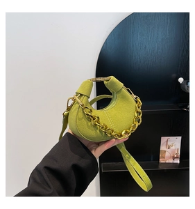 Detalle del bolso de ante verde lima con cadena dorada y correa de hombro desmontable