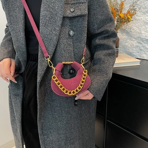 Mini crescent crossbody bag in burgundy suede leather with a chunky gold chain strap