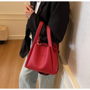 Close-up of red lychee pattern bucket bag with double handles and drawstring closure