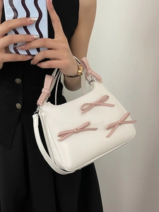 White leather handbag with pink 3D bows shown in a stylish lifestyle selfie shot
