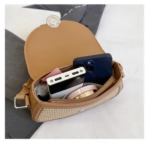 Detail view of woven saddle bag interior showing space for phone and makeup accessories
