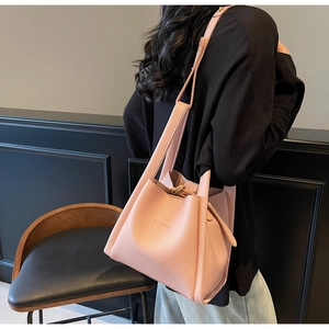 Pale pink bucket bag with litchi texture shown on model for realistic size proportion