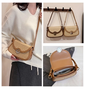 Detail view of woven saddle bag with leather trim, metal buckle and interior compartments