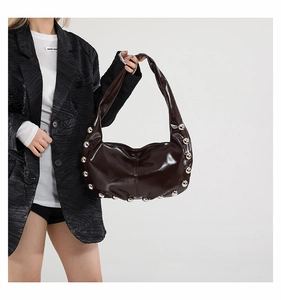 Detailed side view of deep brown oily leather hobo bag with large silver stud accents