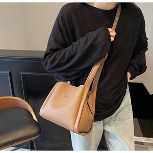 Close-up of caramel lychee grain leather bucket bag with elegant metal hardware