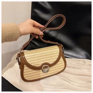 Close-up of wood-color straw weaving and premium brown leather trim on crossbody bag