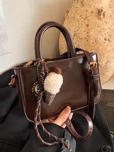 Borsa a tracolla in pelle cerata marrone vintage con ciondolo peluche e hardware dorati