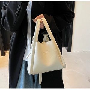 Close-up of white lychee pattern leather bucket bag featuring BAMBOO embossed text