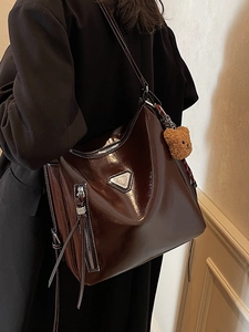 Deep brown oversized glossy patent leather hobo bag with teddy pendant and silver plaque