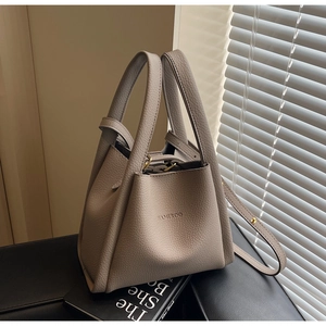 Detail shot of beige lychee pattern bucket bag with HAMIROO logo and gold hardware