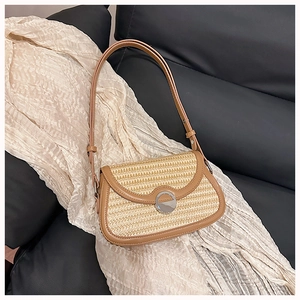 Close-up detail of contrast straw woven bag with brown leather trim and metal buckle