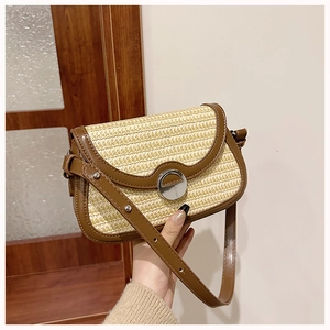 Detail showing woven beige texture with brown leather trim and silver metal twist lock