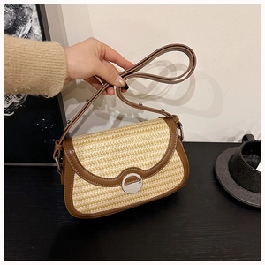 Detail of vintage woven straw crossbody bag with brown leather trim and metal clasp