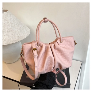 Vue détaillée du cuir grainé rose et du design plissé nuage de ce sac à main élégant