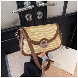 Detail of woven crossbody bag with brown faux leather trim and silver metal lock closure