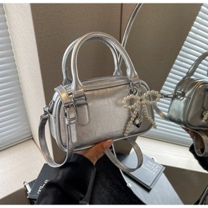 Detailed macro view of silver Boston bag with glossy oil wax finish and pearl bow charm