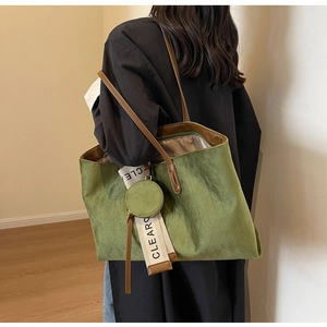 Quilted green velvet tote bag with brown leather straps shown on model in minimal room