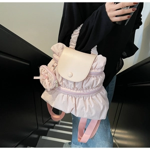 Detailed close-up of pink pleated nylon backpack with a heart-shaped bow coin purse