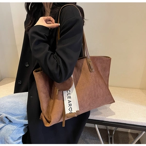 Detail of a brown suede tote bag with CLEAR heart ribbon and small round coin purse