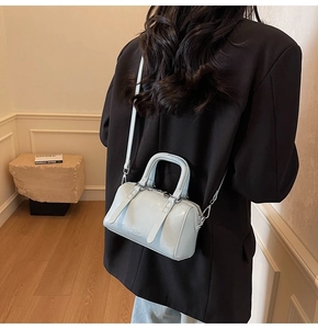 Mannequin portant un sac Boston bleu clair avec un blazer noir et un jean denim