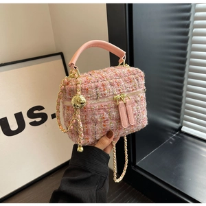 Detail einer rosa Tweed-Handtasche mit Ledergriff und goldener Ketten-Detailansicht
