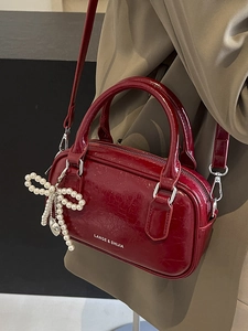 Deep red oil wax leather Boston bag with pearl bow charm and crossbody strap