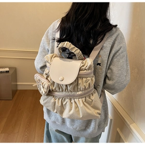 Detail of a beige ruched nylon backpack with a matching circular coin purse charm