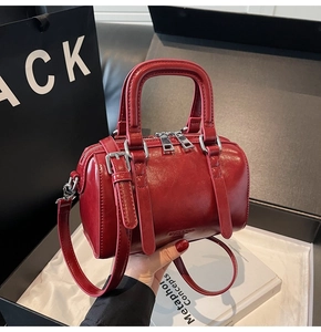 Détail du sac Boston bordeaux en cuir huilé brillant avec quincaillerie argentée élégante