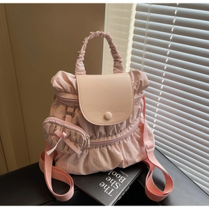 Close-up of pink pleated nylon backpack with ruffles and matching mini bow purse charm