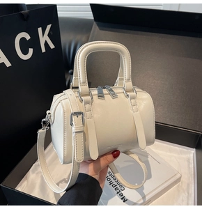 Détail du sac Boston crème avec ferrures argentées et bandoulière réglable