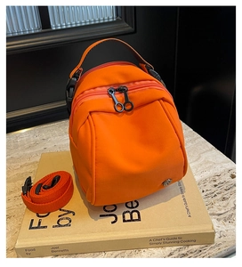 Dettaglio della mini borsa in nylon arancione con doppia cerniera e tracolla staccabile