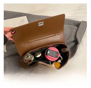 Internal capacity of the brown matte crossbody bag showing organized daily essentials
