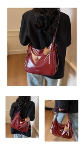 Detailansicht der weinroten Leder-Tote-Bag mit silbernem Logo und Plüsch-Anhänger