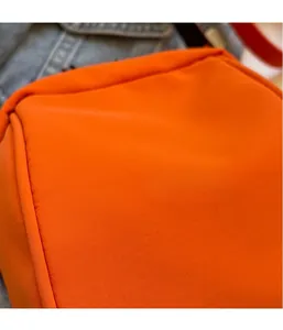 Dettaglio della trama del tessuto ripstop arancione brillante con micro-griglia sulla borsa