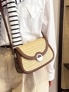 Chic woven straw crossbody bag with brown leather trim and silver round buckle