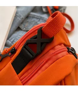 Dettaglio della borsa in nylon ripstop arancione con fibbia nera e cinturino in tela