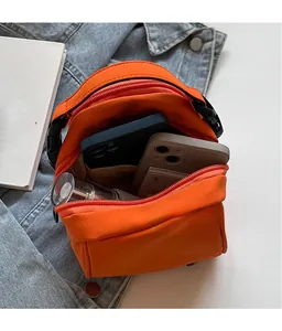 Dettaglio della borsa sportiva in nylon arancione con ampio spazio interno per cellulari