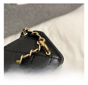 Detail shot of the golden chain link and premium black quilted leather bag