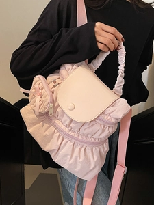 Pink pleated backpack with fluffy cloud texture and decorative bow charm on a model
